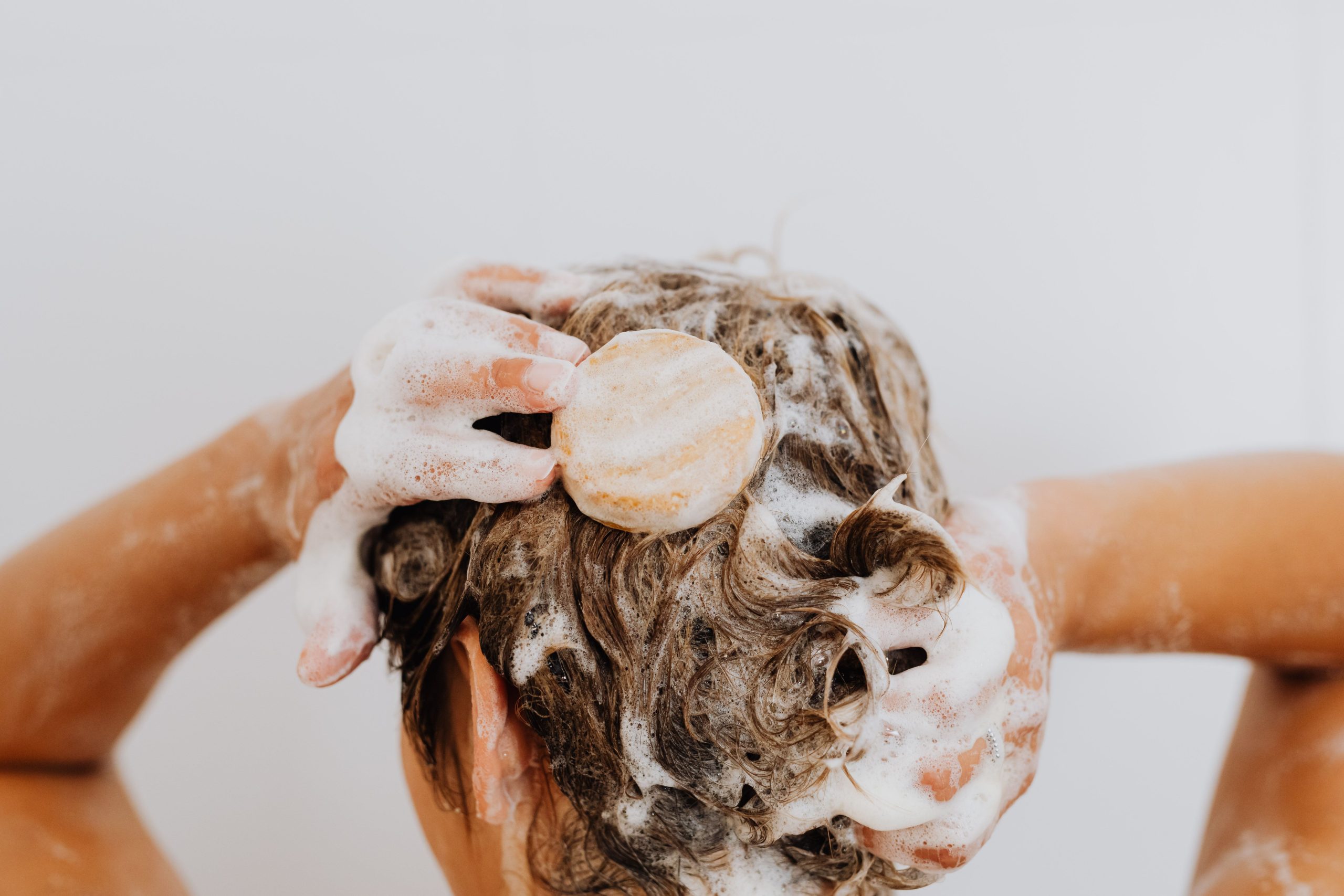 Gros plan lavage cheveux avec savon bar mousse