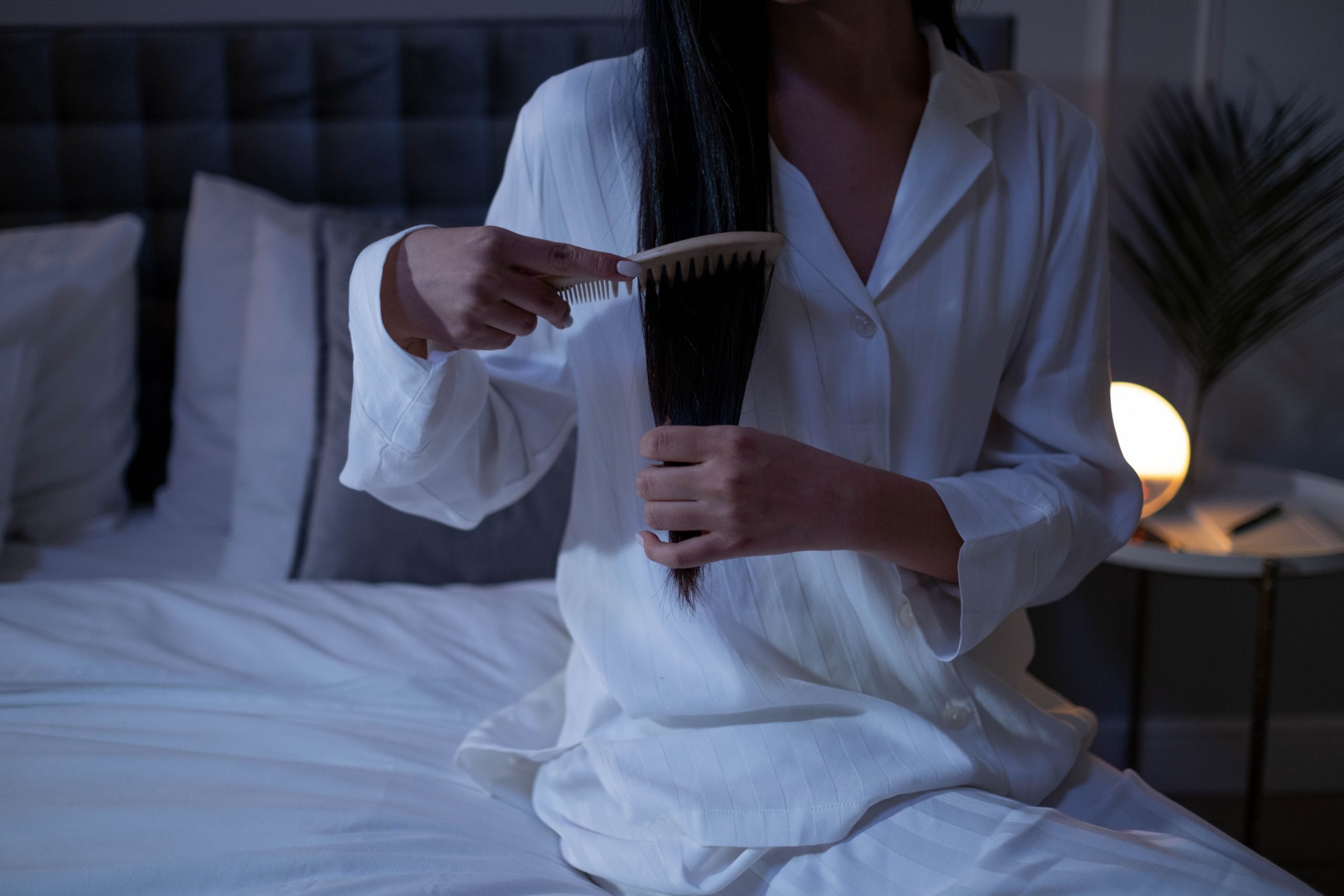Femme en pyjama coiffant cheveux longs