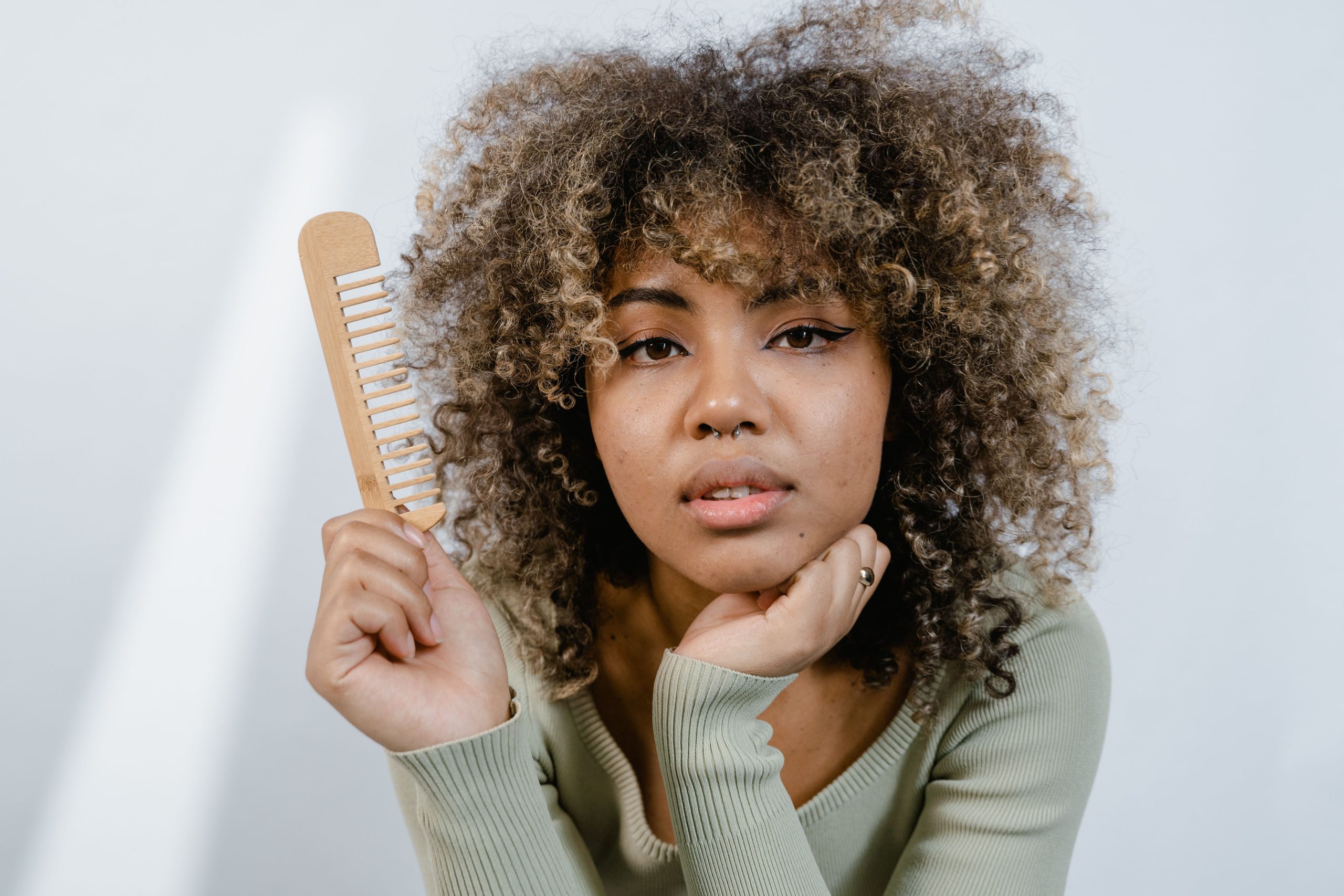 Jeune femme aux cheveux afro tenant une brosse