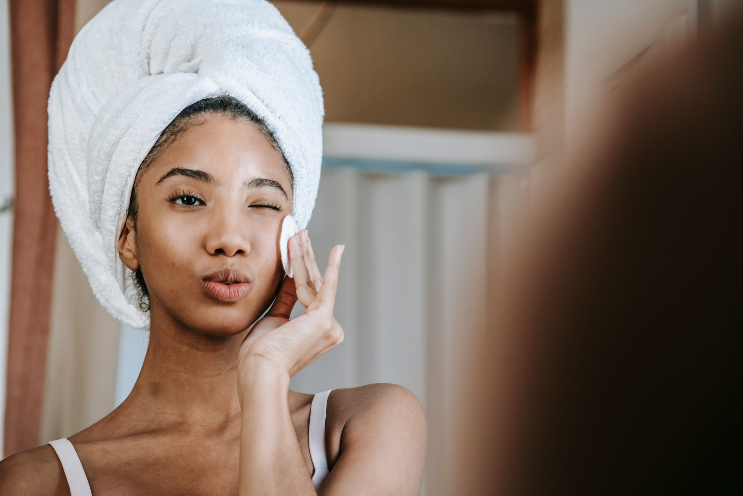 Femme souriante démaquillant son visage quotidiennement