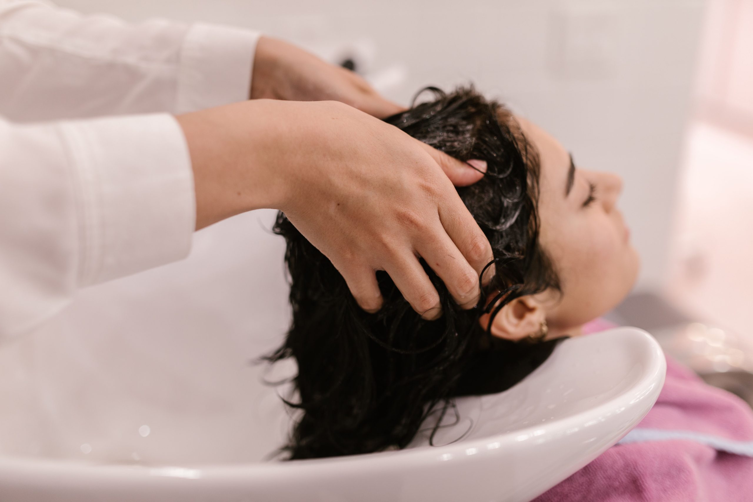 Femme profitant d'un lavage de cheveux relaxant