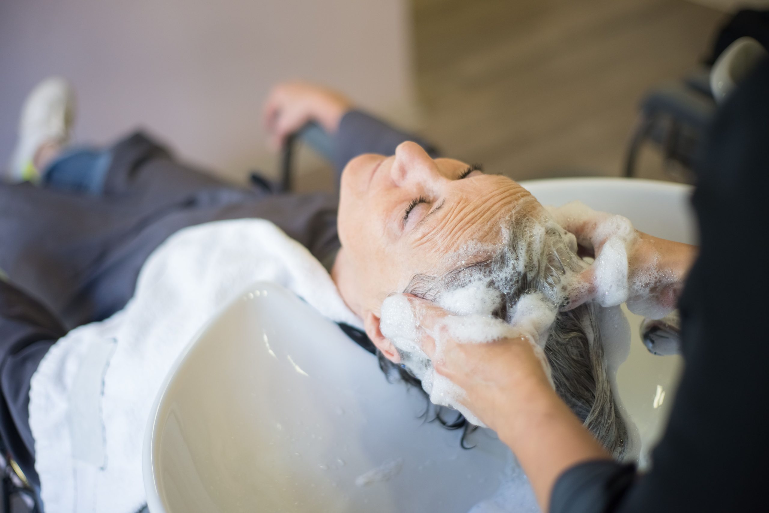 Femme savourant un massage du cuir chevelu moussant